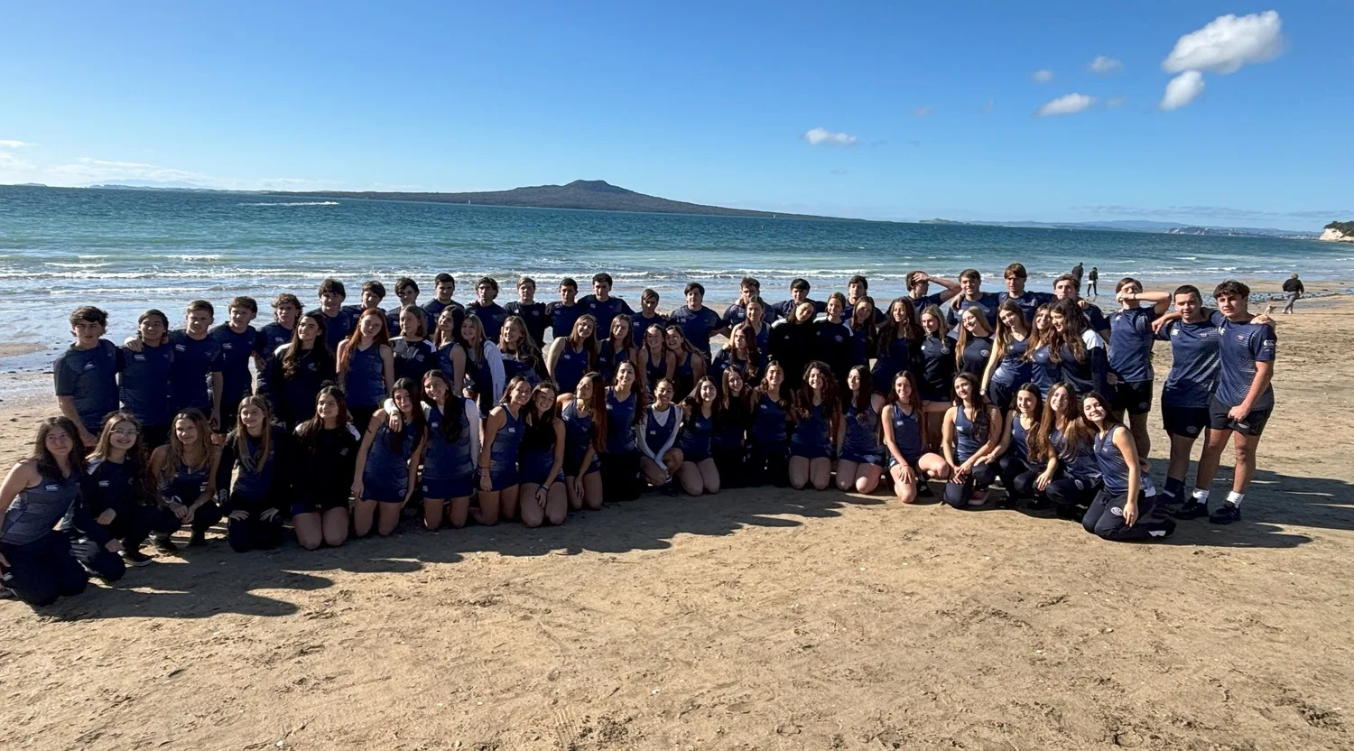 A touring team relaxing together on a New Zealand beach